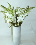 Tall floral arrangement including snapdragon, stock, and lisianthus. 