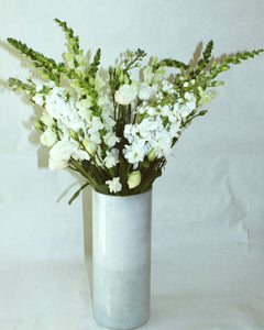 Tall floral arrangement including snapdragon, stock, and lisianthus. 