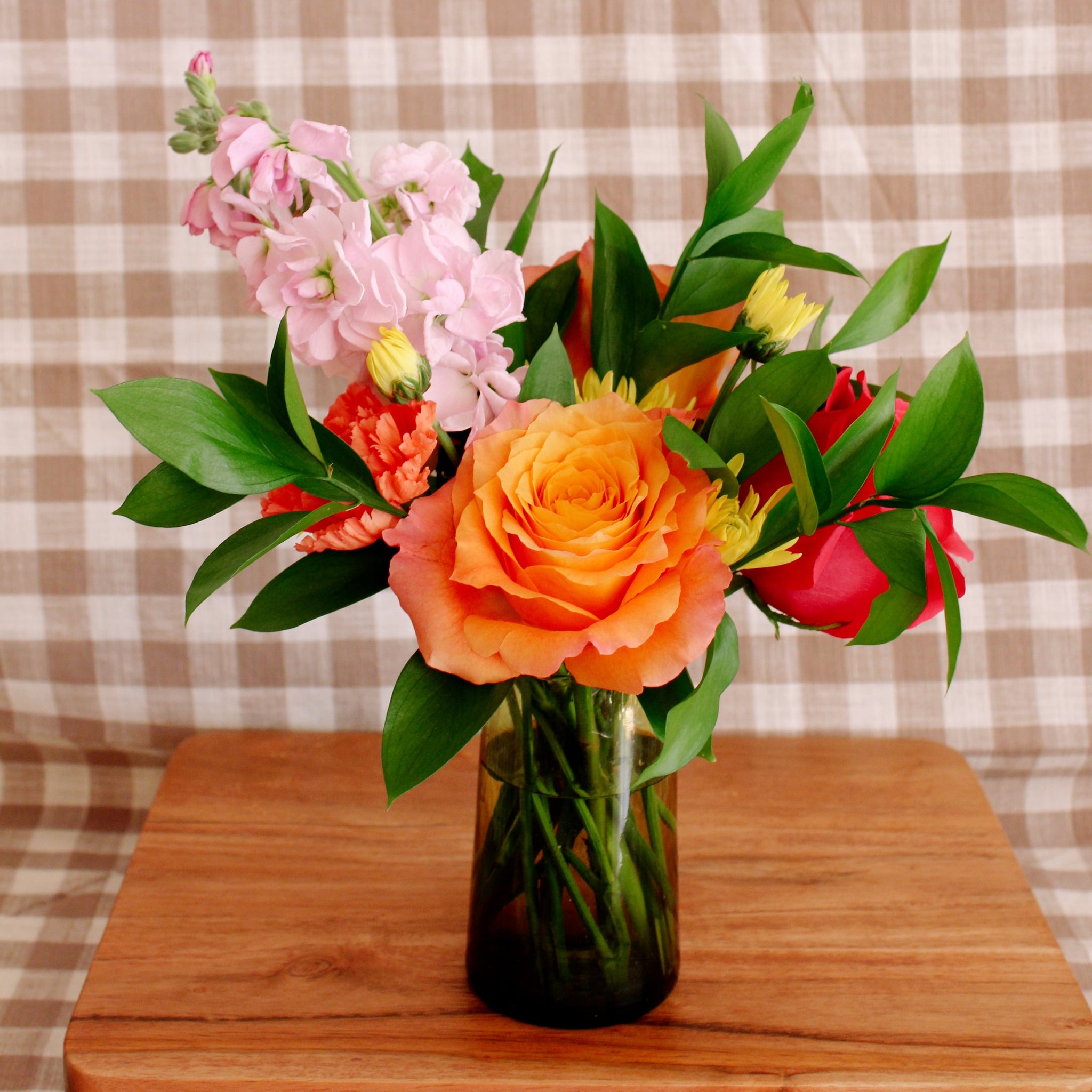 Petite brightly colored floral arrangement in a handmade Moroccan glass.